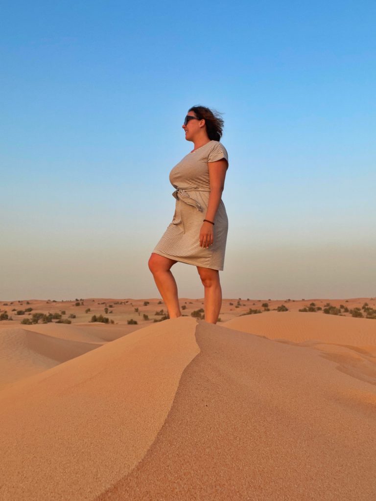 Al Maha sundowner activity - woman stands on sand dune